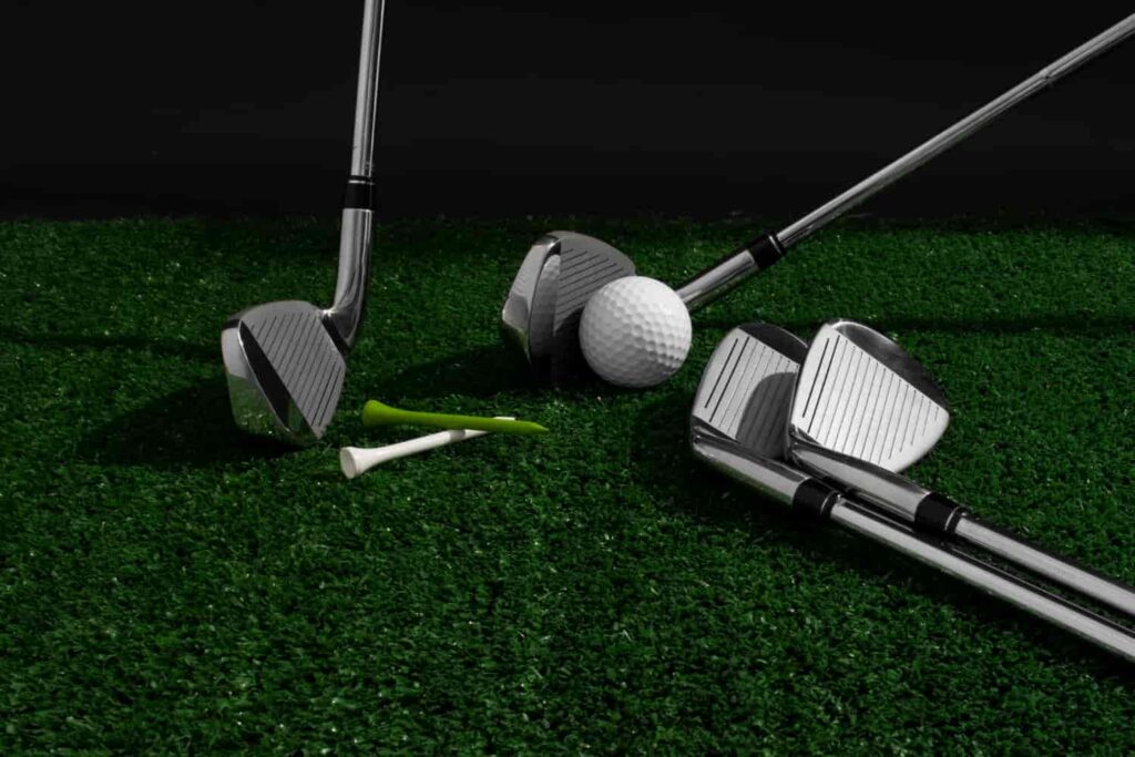 „Golfschläger, Golfball und Tees auf Kunstrasen